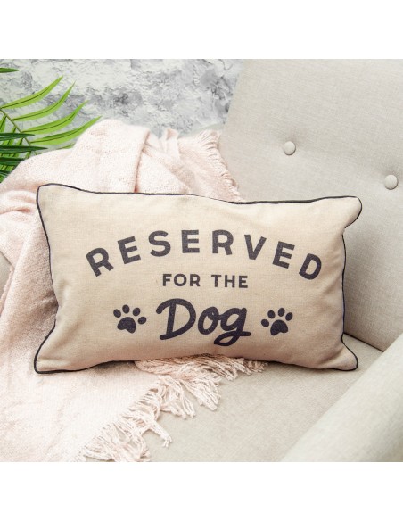 Dekoratyvinė pagalvė su užrašu "reserved for dog" ant fotelio interjere